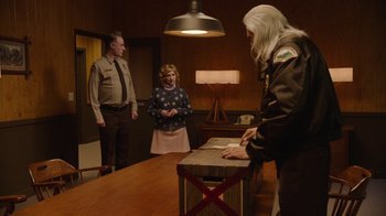 Movie still from “Twin Peaks” (2017), directed by David Lynch – A man and a woman standing in front of a table; Medium shot, High angle
