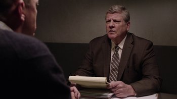 Movie still from “Twin Peaks” (2017), directed by David Lynch – An older man in a brown suit is holding a book; Close Up shot, Over the shoulder angle