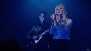 Movie still from “Twin Peaks” (2017), directed by David Lynch – A man and a woman singing into microphones; Medium shot, Low angle