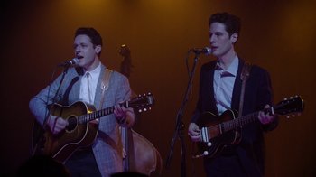 Movie still from “Twin Peaks” (2017), directed by David Lynch – A couple of men are playing a guitar and a guitar; Medium shot, Low angle