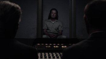 Movie still from “Twin Peaks” (2017), directed by David Lynch – A man sitting in a dark room next to a sound board; Medium shot, Over the shoulder angle