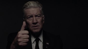 Movie still from “Twin Peaks” (2017), directed by David Lynch – A man in a suit and tie holding a cell phone; Close Up shot, Low angle