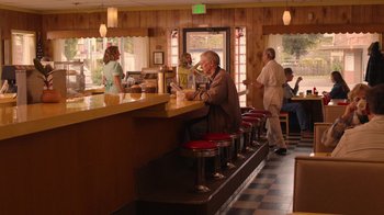 Movie still from “Twin Peaks” (2017), directed by David Lynch – A man sitting at a counter in a restaurant; Wide shot, High angle