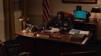 Movie still from “Twin Peaks” (2017), directed by David Lynch – A man sitting at a desk in front of a computer; Medium shot, Over the shoulder angle