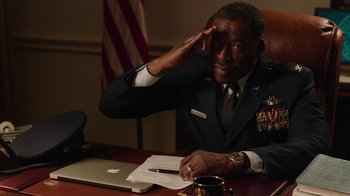 Movie still from “Twin Peaks” (2017), directed by David Lynch – A man in a military uniform sitting at a desk; Medium shot, Low angle