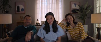 Movie still from “Anonymously Yours” (2021), directed by Maria Torres – A group of people sitting in a living room together; Medium shot, Over the shoulder angle