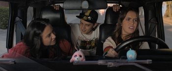 Movie still from “Anonymously Yours” (2021), directed by Maria Torres – A group of young people sitting in the back of a car; Medium shot, Over the shoulder angle