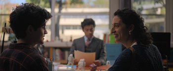 Movie still from “Anonymously Yours” (2021), directed by Maria Torres – Two men sitting at a table talking to each other; Close Up shot, Over the shoulder angle