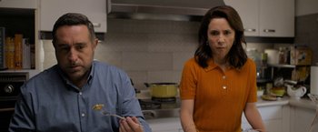 Movie still from “Anonymously Yours” (2021), directed by Maria Torres – A man and a woman in a kitchen eating food; Medium shot, Over the shoulder angle