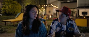 Movie still from “Anonymously Yours” (2021), directed by Maria Torres – A man and a woman sitting next to each other in front of lights; Close Up shot, Over the shoulder angle