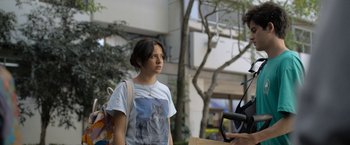 Movie still from “Anonymously Yours” (2021), directed by Maria Torres – A woman standing in front of a tree; Medium shot, Over the shoulder angle