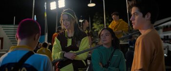 Movie still from “Anonymously Yours” (2021), directed by Maria Torres – Two young women are watching a game at night; Medium shot, Over the shoulder angle