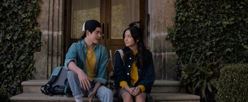 Movie still from “Anonymously Yours” (2021), directed by Maria Torres – Two young people sitting on steps talking to each other; Medium shot, Over the shoulder angle