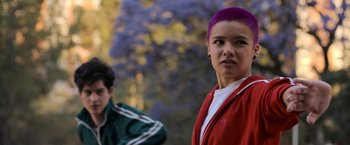 Movie still from “Anonymously Yours” (2021), directed by Maria Torres – A woman with purple hair standing in front of a man; Medium shot, Over the shoulder angle