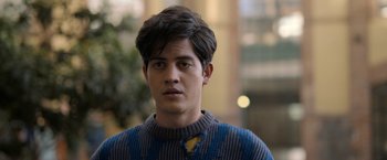 Movie still from “Anonymously Yours” (2021), directed by Maria Torres – A young man wearing a blue and grey sweater; Close Up shot, Over the shoulder angle