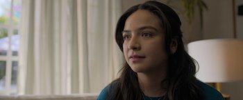 Movie still from “Anonymously Yours” (2021), directed by Maria Torres – A woman with long brown hair sitting in front of a window; Close Up shot, Over the shoulder angle
