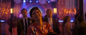 Movie still from “Anonymously Yours” (2021), directed by Maria Torres – A man in a red shirt is looking up at the ceiling; Medium shot, Low angle