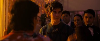 Movie still from “Anonymously Yours” (2021), directed by Maria Torres – A group of young people standing around each other; Medium shot, Over the shoulder angle