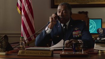 Movie still from “Twin Peaks” (2017), directed by David Lynch – A man sitting at a desk talking on a phone; Medium shot, Low angle