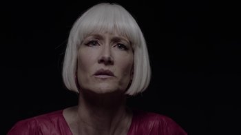 Movie still from “Twin Peaks” (2017), directed by David Lynch – An older woman with white hair and wearing a pink shirt; Close Up shot, Over the shoulder angle