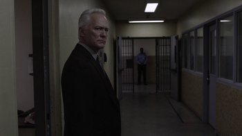 Movie still from “Twin Peaks” (2017), directed by David Lynch – An older man in a suit standing in a jail cell; Medium shot, Over the shoulder angle