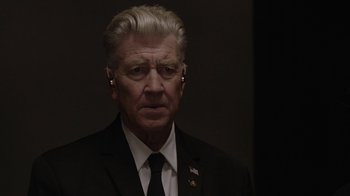 Movie still from “Twin Peaks” (2017), directed by David Lynch – A person wearing a suit and tie; Close Up shot, Over the shoulder angle
