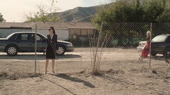 Movie still from “Twin Peaks” (2017), directed by David Lynch – A woman standing in front of a fence with a car behind it; Extreme Wide shot, Low angle
