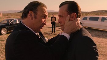 Movie still from “Twin Peaks” (2017), directed by David Lynch – Two men in suits and ties touching each other's ears; Close Up shot, Over the shoulder angle