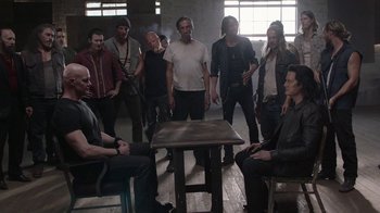 Movie still from “Twin Peaks” (2017), directed by David Lynch – A group of people standing around a table; Wide shot, Over the shoulder angle