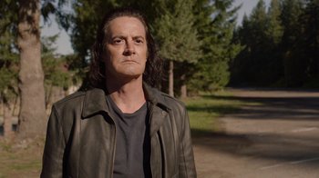 Movie still from “Twin Peaks” (2017), directed by David Lynch – A man with long black hair wearing a leather jacket; Close Up shot, Over the shoulder angle
