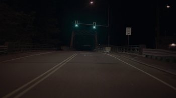 A green traffic light hanging over a bridge