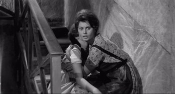 Movie still from “Two Women” (1960), directed by Vittorio De Sica – A woman sitting on a chair with a backpack; Medium shot, High angle