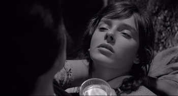 Movie still from “Two Women” (1960), directed by Vittorio De Sica – A young woman looking into a mirror while holding a drink; Close Up shot, Over the shoulder angle