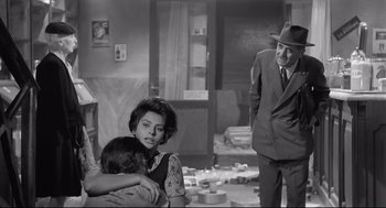 Movie still from “Two Women” (1960), directed by Vittorio De Sica – An old photo of a man and a woman and two children; Medium shot, Low angle