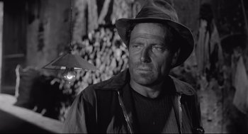 Movie still from “Two Women” (1960), directed by Vittorio De Sica – A man wearing a hat standing in front of trees; Close Up shot, Low angle