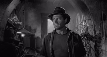 Movie still from “Two Women” (1960), directed by Vittorio De Sica – A black and white photo of a man wearing a hat; Medium shot, Low angle