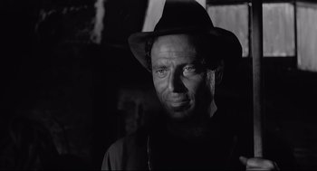 Movie still from “Two Women” (1960), directed by Vittorio De Sica – A black and white photo of a man wearing a hat; Close Up shot, Low angle