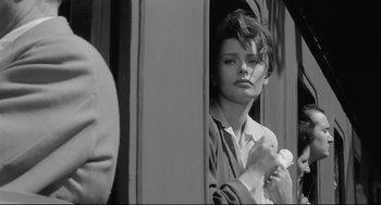 Movie still from “Two Women” (1960), directed by Vittorio De Sica – A young woman holding a baby in her arms while looking out a window; Close Up shot, Over the shoulder angle