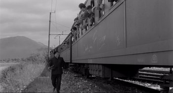Movie still from “Two Women” (1960), directed by Vittorio De Sica – A black and white photo of a man walking on the train tracks; Wide shot, Low angle