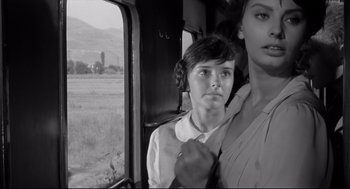 Movie still from “Two Women” (1960), directed by Vittorio De Sica – A woman and a boy are standing next to each other on a train; Close Up shot, Low angle