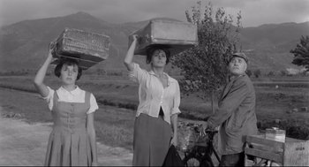 Movie still from “Two Women” (1960), directed by Vittorio De Sica – A group of people standing next to each other on a field; Medium shot, Low angle