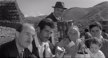 Movie still from “Two Women” (1960), directed by Vittorio De Sica – A group of men and women standing next to each other; Medium shot, Low angle