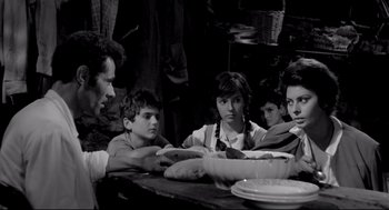 Movie still from “Two Women” (1960), directed by Vittorio De Sica – A group of people sitting around a table; Medium shot, High angle