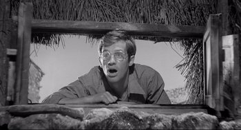 Movie still from “Two Women” (1960), directed by Vittorio De Sica – A man with glasses is looking over a wall; Close Up shot, Low angle