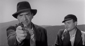 Movie still from “Two Women” (1960), directed by Vittorio De Sica – A man holding a gun while standing next to another man; Medium shot, Low angle