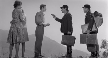 Movie still from “Two Women” (1960), directed by Vittorio De Sica – Two men and a woman are standing in a field; Wide shot, Over the shoulder angle