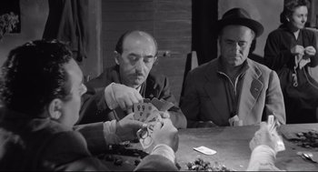 Movie still from “Two Women” (1960), directed by Vittorio De Sica – Three men sitting at a table playing a card game; Medium shot, Over the shoulder angle