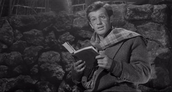 Movie still from “Two Women” (1960), directed by Vittorio De Sica – A man is reading a book while wearing glasses; Medium shot, Low angle