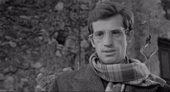 Movie still from “Two Women” (1960), directed by Vittorio De Sica – A black and white photo of a man wearing glasses and a scarf; Close Up shot, Low angle