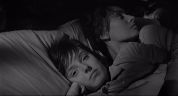 Movie still from “Two Women” (1960), directed by Vittorio De Sica – Two people laying in bed with one of them looking at the camera; Close Up shot, High angle